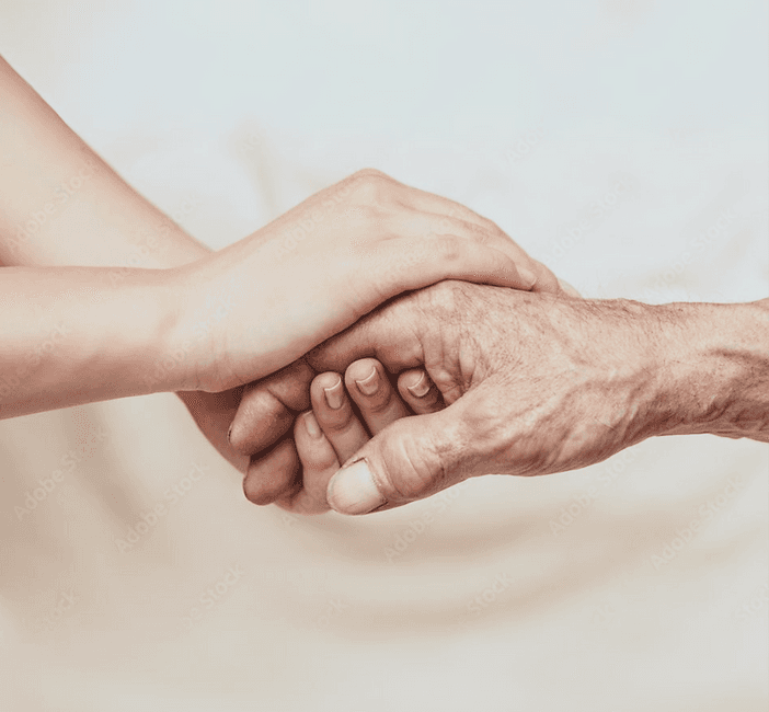 A young hand resting on the hand of an older person